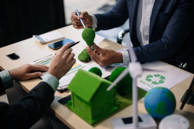 Geri dönüşüm planlayan ve tartışan iş adamları ofis toplantı odasında yeniden kullanım politikası sembolünü azalttı. Yeşil iş şirketi ve Güneş Enerjisi Çevre Kenti Kavramı.
