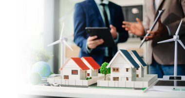 Emlak komisyoncusu, emlak kredisi teklifiyle ilgili sözleşme imzalama anlaşmasını, ev modelini sunar ve müşteriye danışmanlık yapar.