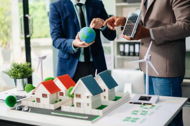 Emlak komisyoncusu, emlak kredisi teklifiyle ilgili sözleşme imzalama anlaşmasını, ev modelini sunar ve müşteriye danışmanlık yapar.