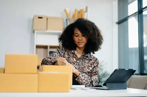 Küçük işletme girişimcisi KOBİ 'de çalışan serbest çalışan kadın ofis, BOX, tablet ve laptop çevrimiçi, pazarlama, paketleme, dağıtım, e-ticaret konsepti