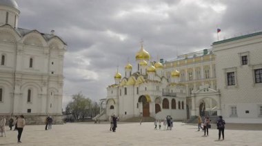 Turistler, Moskova Kremlin topraklarında Başmelek Katedrali 'nin arka planına karşı yürüyorlar. 4k 