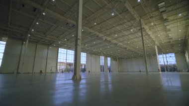 Kocaman, boş bir hangar, panoramik pencereler ve parlak güneş ışığı. Oyuncak bebek kamerası. 4k 