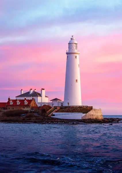 İskoçya, Skye Körfezi 'nde gün batımında güzel beyaz bir deniz fenerinin dikey görüntüsü.