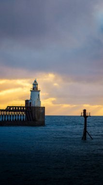 Gün batımında iskelede büyük bir deniz feneri..