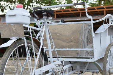 Metal koltuğu ve kırmızı ışığı olan klasik bir çocuk arabası, gündüz vakti vurulmuş. Çevre taşımacılığı, geçmişe yolculuk ya da Asya sokak sahneleri için ideal.