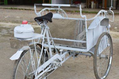 Siyah eyerli ve arka lambalı klasik beyaz bisiklet taksisi, sürdürülebilir ulaşım veya geleneksel seyahat temaları için mükemmel..