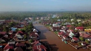Batı Kalimantan 'daki Sambas Nehri boyunca yoğun yerleşim alanlarının hava manzarası, nehir kıyısında kümelenmiş yapışkan evler, tropikal yaşam tarzını ve yerel mimariyi yansıtıyor..
