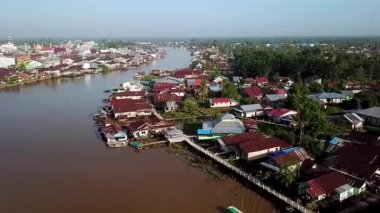 Batı Kalimantan 'daki Sambas Nehri boyunca yoğun yerleşim alanlarının hava manzarası, nehir kıyısında kümelenmiş yapışkan evler, tropikal yaşam tarzını ve yerel mimariyi yansıtıyor..