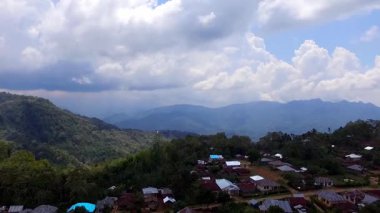 Flores, Endonezya 'daki uzak yamaç köylerinin havadan görünüşü, dağlık adalarda doğal topoğrafya, yemyeşil ve geleneksel kırsal yaşam sergileniyor..
