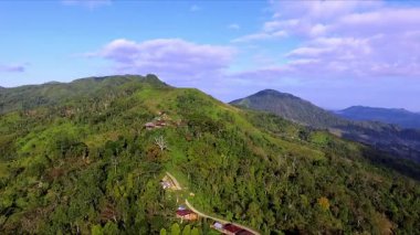 Flores, Endonezya 'daki uzak yamaç köylerinin havadan görünüşü, dağlık adalarda doğal topoğrafya, yemyeşil ve geleneksel kırsal yaşam sergileniyor..