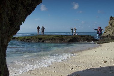 Bali, Endonezya 15 Ocak 2019. Yabancı ve yerel turistlerin, Balis 'in en ikonik deniz kıyılarından biri olan Uluwatu' daki Suluban Sahili 'nde altın günbatımının keyfini çıkardıkları bir fotoğraf..