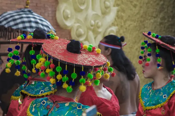 Bali, Endonezya 15 Ocak 2019 canlı geleneksel giyinmiş, kırmızı şapkalı ve renkli ponpon aksesuarlı canlı kültürel bir ortamda kadın dansçılar..