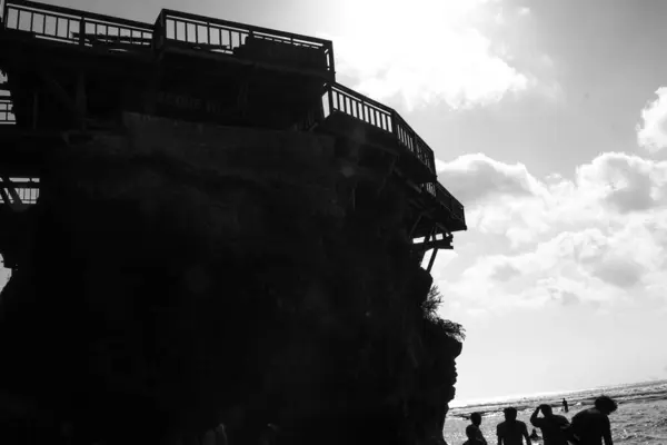 Yabancı ve yerel turistlerin, Balis 'in en ikonik deniz kıyılarından biri olan Uluwatu' daki Suluban Sahili 'nde altın gün batımının keyfini çıkardıkları fotoğraf.