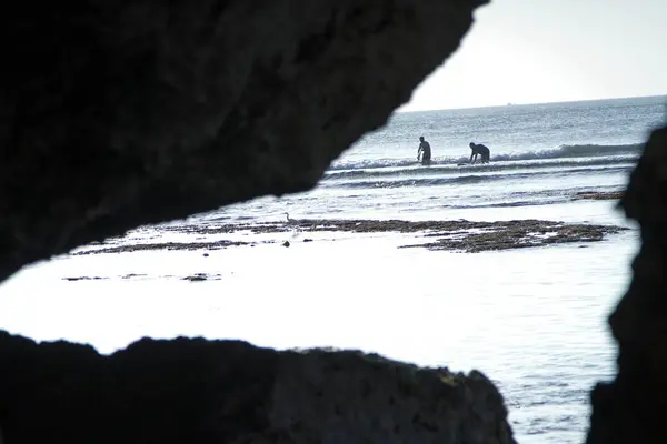 Yabancı ve yerel turistlerin, Balis 'in en ikonik deniz kıyılarından biri olan Uluwatu' daki Suluban Sahili 'nde altın gün batımının keyfini çıkardıkları fotoğraf.