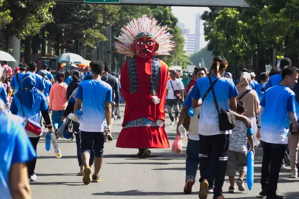 Jakarta, Endonezya - 6 Ocak 2025: Geleneksel bir ondel icracısı Jakarta 'da açık havada egzersiz yapan kalabalığın arasında eğleniyor. Kültürel simge şehir faaliyetleri arasında göze çarpıyor.