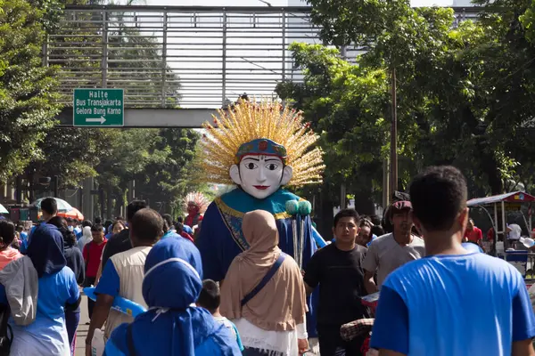 Jakarta, Endonezya - 6 Ocak 2025: Geleneksel bir ondel icracısı Jakarta 'da açık havada egzersiz yapan kalabalığın arasında eğleniyor. Kültürel simge şehir faaliyetleri arasında göze çarpıyor.