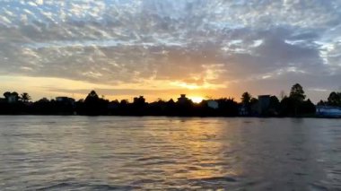 Gün doğumunda Mahakam Nehri 'nin sakin hava manzarası, sakin suların üzerinde süzülen yumuşak sabah sisi ve Doğu Kalimantans tropikal arazisinde günlük yolculuklarına başlayan dağınık tekneler..