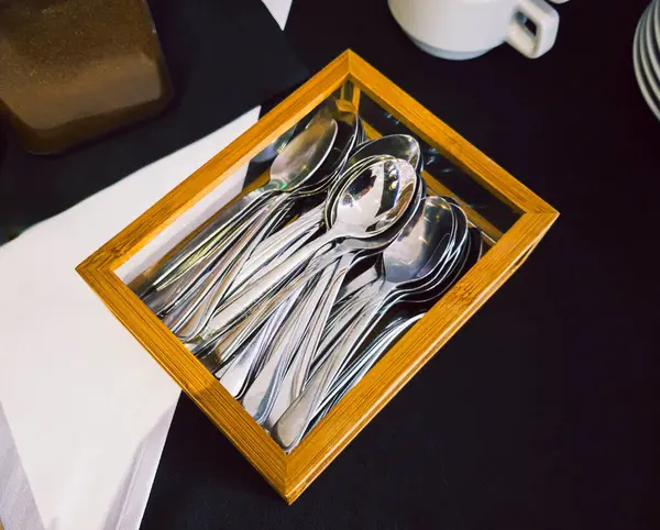 Ahşap bir kutuda çay kaşığı çay takımı.