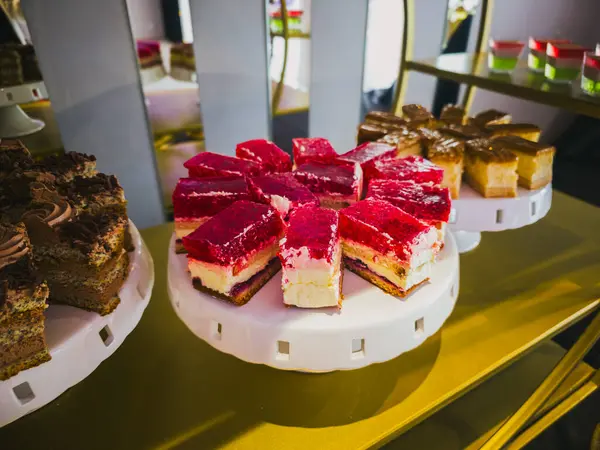 Beyaz tezgahların üzerinde çeşitli gurme kekler zarif bir tatlı gösterisinde