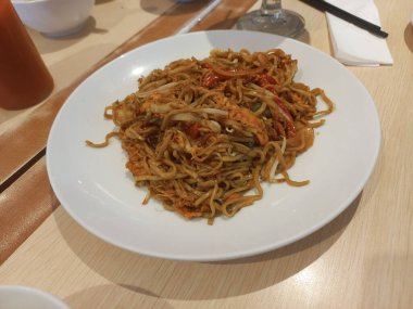  Masanın üzerinde bir tabak deniz mahsulü eriştesi.