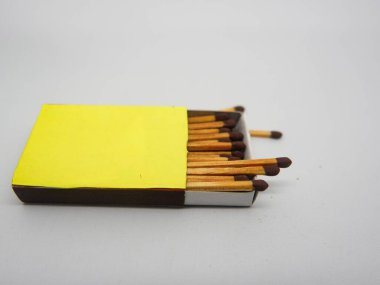 Beyaz arkaplanda sarı kutu ve kahverengi kibrit çöpleri