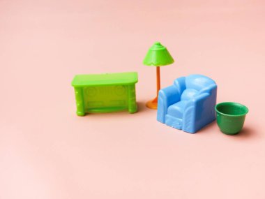 Pembe arka planda plastik mobilya oyuncak evi