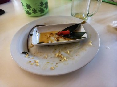 İçinde yiyecek kalıntıları ve acılı garnitür olan boş bir tabak lezzetli bir yemeğin sinyalini veriyor. Öğle yemeği sonrası tatmin..