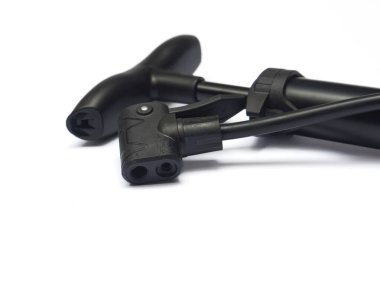 Siyah, taşınabilir bir bisiklet pompasının çift valfli konnektörünün temiz beyaz arka planda uzanan yakın çekim görüntüsü..