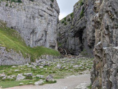 Küçük bir şelale ve dibi yemyeşil çimlerle kaplı dar bir geçitten çarpıcı bir manzara..