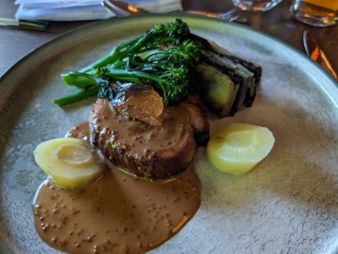 Güzel bir tabakta bol soslu kızarmış et, yanında da sebze ve patates, zarif bir şekilde sunuluyor..