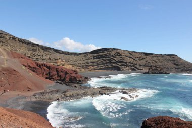 Lanzarote Adası 'nın güzel manzarası. le ressac des vagues de la mersur la roche volique dans une ambiance reposante, le bleu turquoise de l 'eau claire contraste avec la roche volique et ses tons ocres