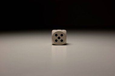 Beş numaralı minimalist tahta zar, düz nötr yüzeye odaklı dramatik yumuşak ışıklandırma oyun, strateji ya da rastgelelik için yaşam sembolü.