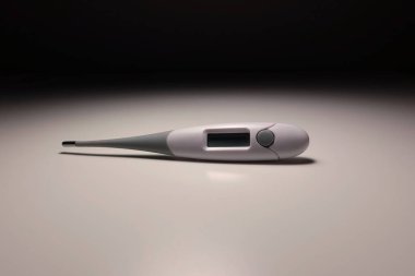 Işık nötr arkaplan üzerine dijital tıbbi termometre, vücut sıcaklığı ölçümü, sağlık ve ateş konsepti için modern Beurer elektronik termometresinin yakın çekimi