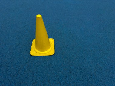 Mavi Kauçuk Spor Sahası Spor Atletizm Alanında Sarı Trafik Eğitim Konisi Açık Hava Egzersizleri ya da Okul Yarışması