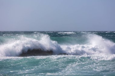 Beyaz köpük ve turkuaz suyla dinamik okyanus dalgaları doğal bir soyut doku yaratıyor. Arka plan olarak mükemmel..
