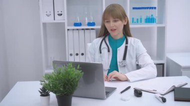 Online danışmanlık yapan bir doktor. Parlak, düzenli bir ofiste oturan doktor, boynunda steteskop olan beyaz bir ceket giyer ve dikkatle dizüstü bilgisayarla bağlanır. Sahne