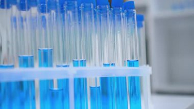 Mikroskop kullanarak bir araştırmacıyı ya da tıp uzmanını gösteren, hassas ve bilimsel araştırmayı vurgulayan bir laboratuvar sahnesinin yakın çekimi. Mavi eldivenli eller test sırasında mikroskobu ayarlar
