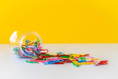 Parlak renkli ataçlar, renk teorisi çalışma alanı ve görsel düzenin planlanması için okul ofis malzemelerinin yaratıcı kaos ve üretkenlik estetiğini ön plana çıkarmaktadır.