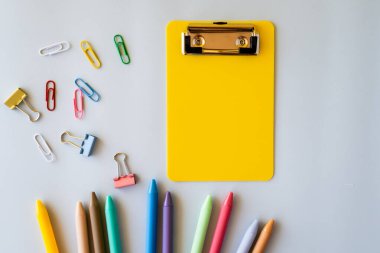 Işık yüzeyi üzerine canlı ofis malzemeleriyle neşeli öğrenme havası ve organize akademik çalışma alanını temsil eden renkli kalemler ve pano ataçları içeren eğlenceli okul kompozisyonu