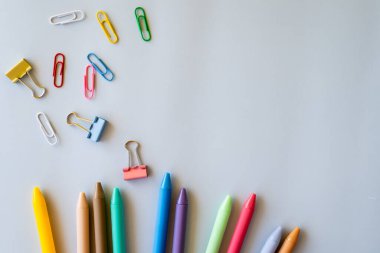 Renkli okul araçları ile yaratıcı kompozisyon nötr yüzey üzerine canlı kalem ataçları ve parlak masa titreşimi ve eğlenceli eğitimsel görsel hikaye anlatımını temsil eden klasörler