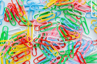 Canlı bir kompozisyonda çok renkli ataçların en üst görünümü, eğitim alanında kaos ve yaratıcılığı yansıtmaktadır. Yaşam tarzı ofis masası temel gereksinimleri ve oyuncu minimalist görsel organizasyon kavramını yansıtır.