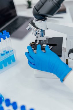 Steril eldivenli ellerin yakınlaştırılması numuneyi mikroskop altına alarak yüksek teknoloji laboratuvarına yerleştirmek akıllı tıp biyoteknoloji araştırmalarında yeniliklerin altını çizmek sağlık hizmetleri araçlarına yönlendirilmiş dijital veri