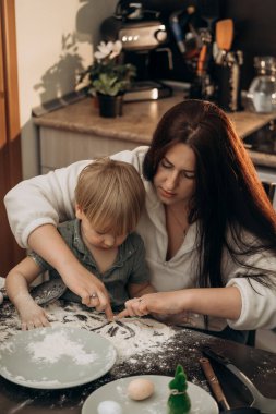 Yaratıcı anne ve çocuk anı un içinde gülümseyen bir güneş çizerken hayal gücü, bağlantı, ev sıcaklığı ve günlük mutfak büyüsüyle dolu duyusal oyun zamanının tadını çıkarıyor.