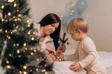 Anne ve çocuğun şenlik zamanı süsleme yaparken birlikte süsledikleri huzurlu anlarında bu sahne anlamlı kutlamaları ve hassas bağlantıları yansıtıyor.