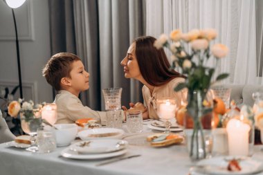 Yürekten bir an, anne oğul mum ışığında gülümserken burunlarına dokunur sıcak sevgi ve yakınlıkla dolu sıcak bir akşamda derin bağlar kurar mükemmel anneler günü duygusal hikaye anlatır.