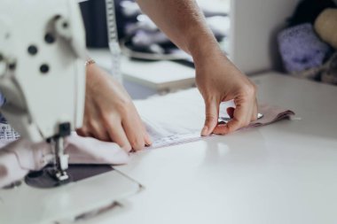 Terzilerin ellerinin yaklaşması, kumaşı dikkatlice ölçmeden önce yumuşak tekstil ile çevrili, huzurlu çalışma alanında yavaş moda sürecini ve el yapımı minimum yaşam tarzını yakalıyor.