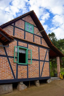 Eski yarı keresteli (Fachwerk) bir ev, açık mavi gökyüzü ile güneşli bir günde, geleneksel Alman tarzı mimari sergilenmektedir. Kültürel mirasın ve zamansız cazibenin resimsel bir sembolü..