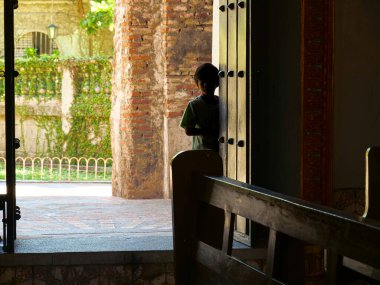 Genç çocuk eski kasabanın eski kilisesinde yürüyor.