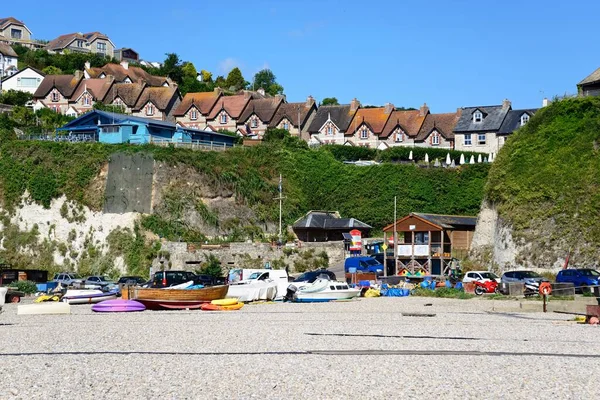 stock image BEER, UK - JULY 14, 2022 - Boats on the pebble beach with cliffs and town buildings to the rear, Beer, Devon, UK, Europe, July 14, 2022.