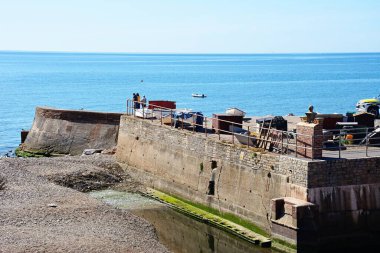 SIDMOUTH, İngiltere - 08 Ağustos 2022 - Gezinti güvertesinin sonunda denize bakan turistler, Sidmouth, Devon, İngiltere, Avrupa, 08 Ağustos 2022.